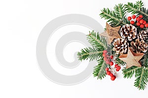 Christmas festive styled floral composition. Pine cones, fir tree branches, red rowan berries and wooden stars on white
