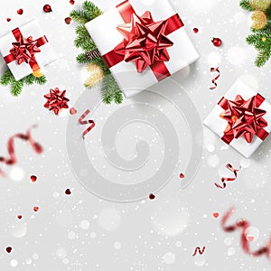 Christmas fir branches, gift box with red ribbon, decoration, sparkles, confetti and bokeh on white background.