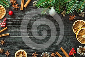 Christmas fir tree branches and pine cones on wooden dark, black background