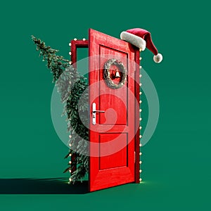 Christmas fir tree enters the red door decorated with lights and Santa hat on green background photo