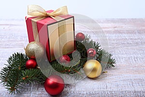 Christmas fir tree with gift box on wooden board