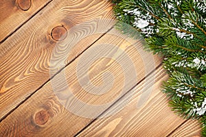 Christmas fir tree with snow on rustic wooden board