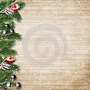 Christmas fir tree with snowfall and berries on a wooden board