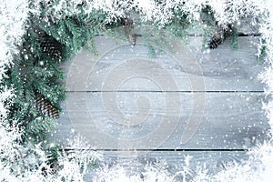 Christmas Firbranch with cones and snowflakes on old wooden rustic background with copy space for text.
