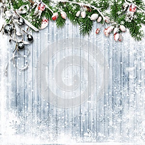 Christmas firtree with holly, snowfall on wooden white board