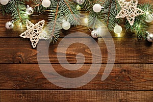 Christmas flat lay composition with pine tree branches decorated Xmas garland, baubles, stars on wooden background. Christmas