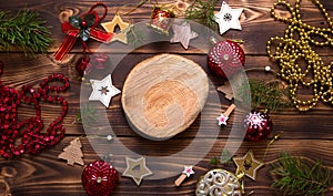 Christmas flat lay of red balloons and wooden stars and clothespins on a dark background with tree trunk section for notes in cent