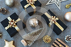 Christmas flat lay, toys, baubles and black wrapped gift boxes with golden ribbon. Top view, flat lay