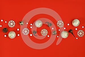 Christmas flat lay with wooden snowflake ornaments, golden bells and balls and tree ornament baubles forming line