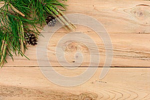 Christmas flatlay on a rustic wooden background: green pine needles with cones.