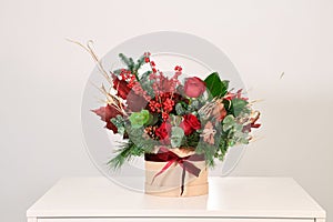 Christmas bouquet of red and green flowers in a gift box on a white backgroun photo