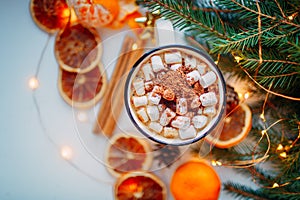 Christmas food background presented by a cup of coffee with marshmallow, cinnamon rolls and orange dry slices