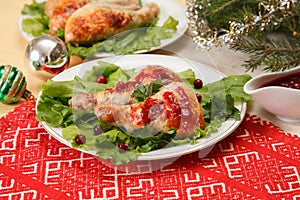 Christmas food: baked chicken leg with cranberry sauce