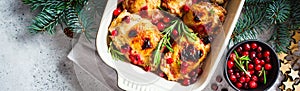 Christmas food. Baked Chicken meat with cranberries and rosemary in the oven dish, white background, banner