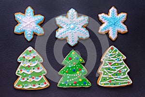 Christmas food, handmade cookies gingerbread like christmas trees and snowflakes on black background