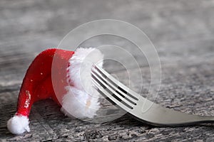 Christmas food menu abstract background with fork and santa claus hat on table