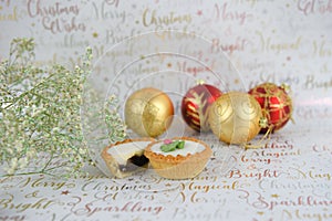 Christmas food photography of flowers with glitter mince pies baubles on xmas wrapping paper background