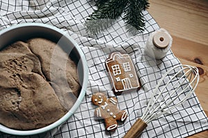 Christmas food photography. Gingerbread cookies, dough and fir tree branch. Wooden table. Festive baking concept