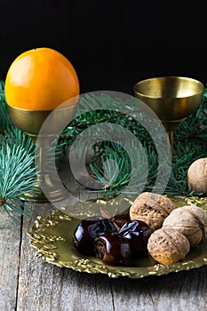 Christmas food still life: arabic dates, walnuts, persimmon