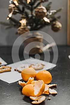 Christmas Food Waste. Reducing festive food waste. Peeled oranges on a table with a festive Christmas tree adorned with
