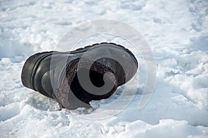 Christmastide. Old worn rustic boot thrown on white snow indicates where the bride or groom will appear photo