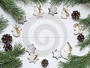 Christmas frame, background for greeting card. Decoration, fir tree, choco and sugar-glaze cookies on white wooden table. Top view