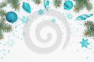 Christmas frame of fir branch, blue decoration and snowflake on white background. Holiday frame. Flat lay, top view