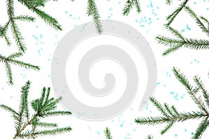 Christmas frame of fir branches with blue snowflakes on white background. Flat lay