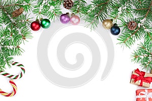 Christmas Frame of Fir tree branch with candy canes and balls isolated on white background with copy space for your text