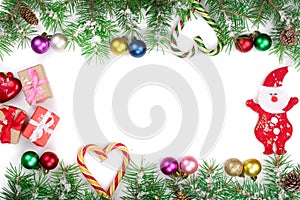 Christmas Frame of Fir tree branch with candy canes and balls isolated on white background with copy space for your text