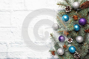 Christmas frame made of fir, Christmas tree decorations in silver and blue on a light brick background. Copy space. Flat lay