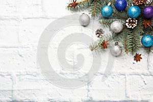 Christmas frame made of fir, Christmas tree decorations in silver and blue on a light brick background. Copy space. Flat lay