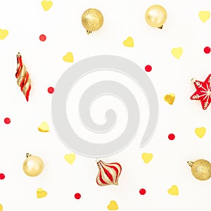 Christmas frame made of golden and red decorations with confetti on white background. Flat lay