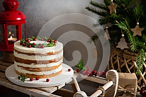 Christmas fruit cake, pudding on wooden sleigh with christmas tree, presents and decorations on the background. Traditional New