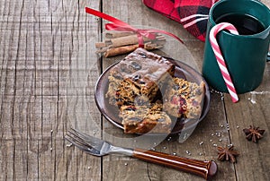 Christmas fruit cake and tea over rustic wooden background