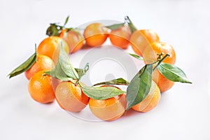 Christmas fruit. Orange fresh tangerines or mandarines with green leaves lie on a white background