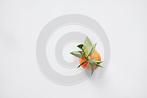 Christmas fruit. Orange fresh tangerines or mandarines with green leaves in a paper bag lie on a white background