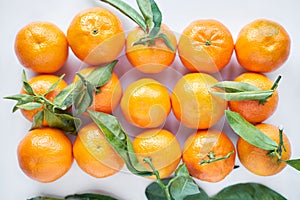 Christmas fruit. Orange fresh tangerines or mandarines with green leaves in a paper bag lie on a white background