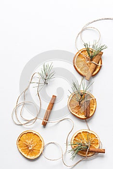 Christmas garland of dried oranges, pine twigs and cinnamon sticks strung on a string.