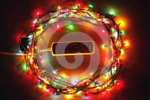 Christmas garland lights circle around electric extension cord