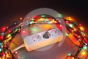 Christmas garland lights circle around electric extension cord