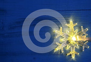 Christmas garland lights.LED snowflake shaped bulb on blue wooden background.