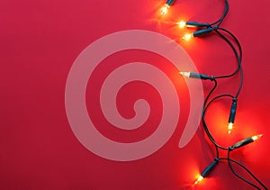 Christmas garland lights on red paper background