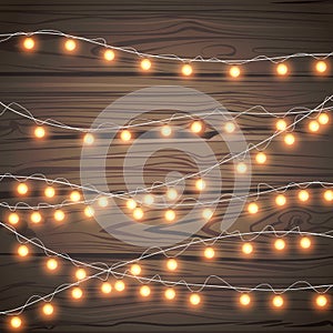 Christmas garlands isolated on wooden background. Xmas realistic overlay golden lights card. Holidays decorations bright