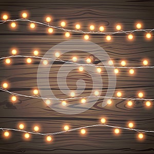 Christmas garlands isolated on wooden background. Xmas realistic overlay golden lights card. Holidays decorations bright