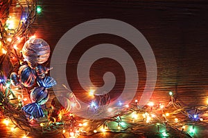 Christmas garlands of lamps on a wooden background.