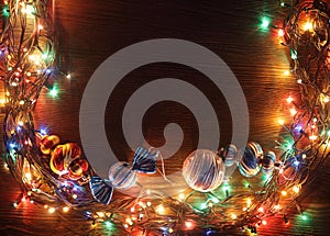 Christmas garlands of lamps on a wooden background.