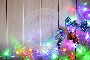 Christmas garlands of lamps on a wooden background.