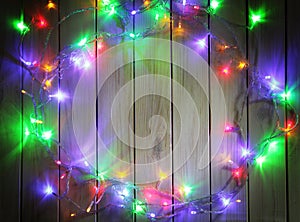 Christmas garlands of lamps on a wooden background.