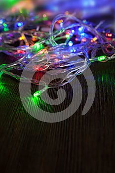 Christmas garlands of lamps on a wooden background.